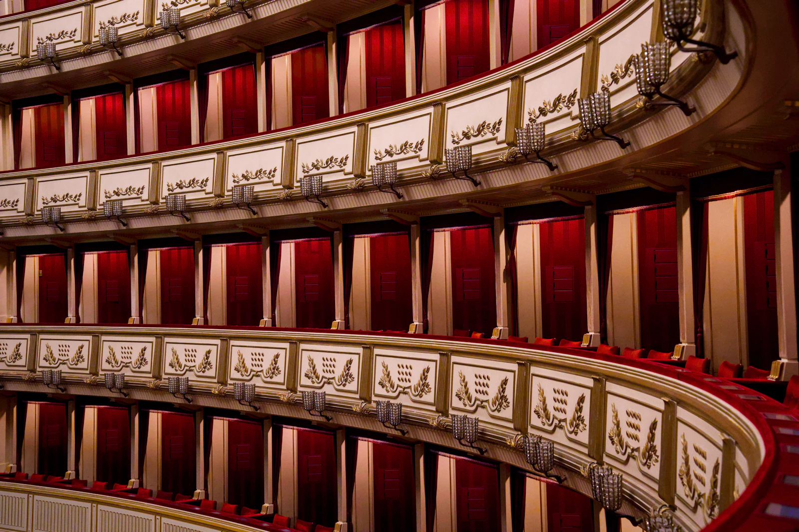 Balcões de um teatro de ópera com cortinas de veludo vermelho